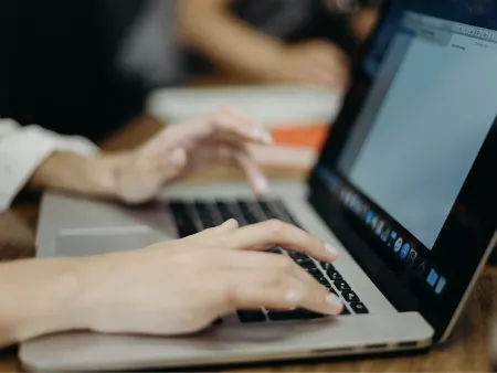 Imatge de les mans duna persona escrivint en un portàtil